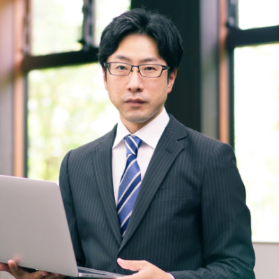 ノートパソコンを抱えたメガネの男性ビジネスマン